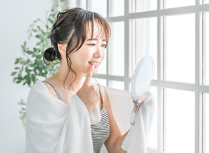 鏡でチェックする女性