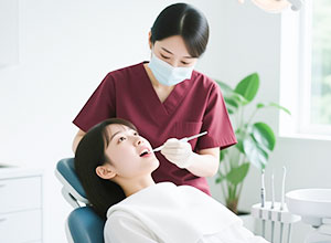 歯科衛生士にクリーニングを受ける女性