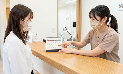 歯医者で日程を確認する女性