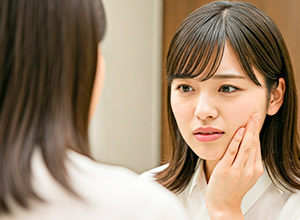 頬をおさえる女性