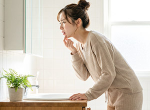鏡で口腔内を確認する女性