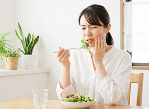 歯に痛みを感じる女性