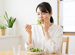 食事中に歯に痛みを感じる女性